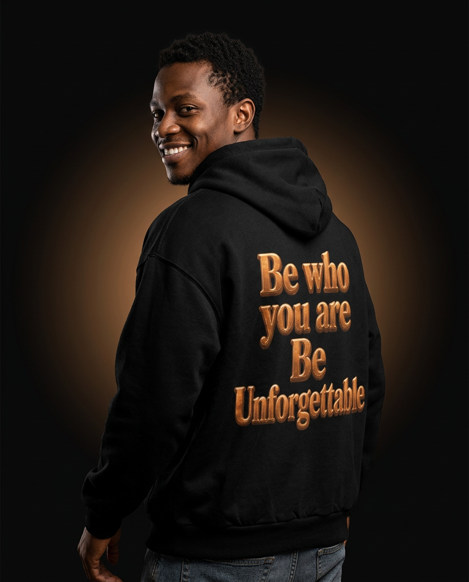 Model wearing the MR. HAPPINESS "Be Unforgettable" Hoodie back view showing the bronze "Be who you are · Be Unforgettable" artwork